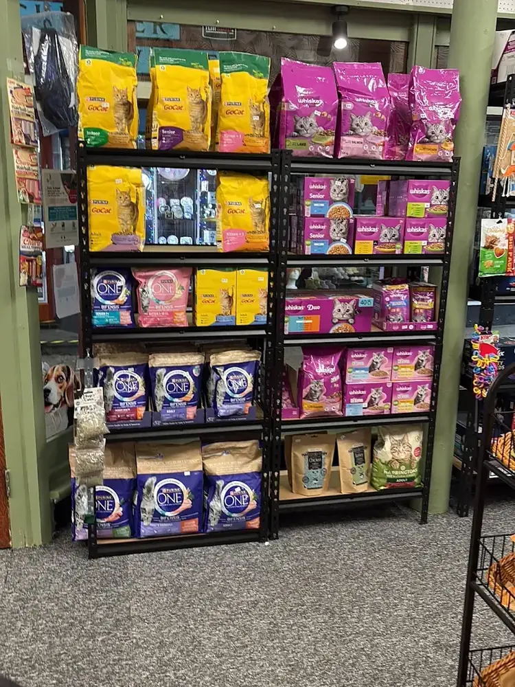 Stacked food-bag wall at Paws'n'Moors — Wagg, Naturo and multiple complete-meal brands across the height of the shelving.
